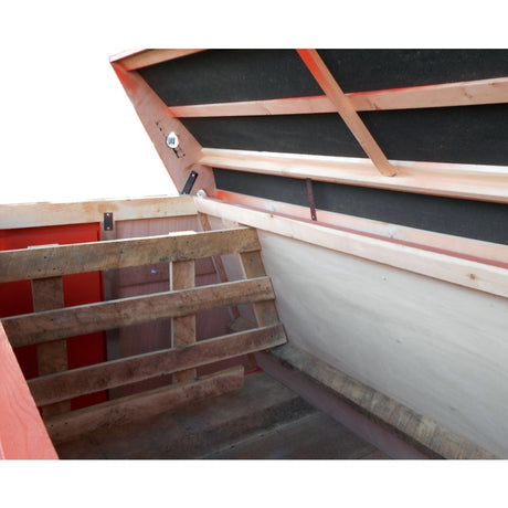 Inside the Smidley farrowing house, showing the removable oak cross divider, the pig rail along the sloping side and the oak floor